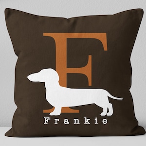 May include: Brown throw pillow with a white dachshund silhouette and the letter "F" in orange. The name "Frankie" is printed in white below the dachshund.