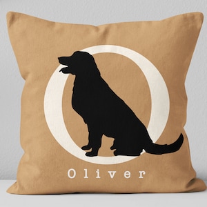 May include: A tan throw pillow with a white circle and a black silhouette of a dog inside. The text "Oliver" is printed below the circle.