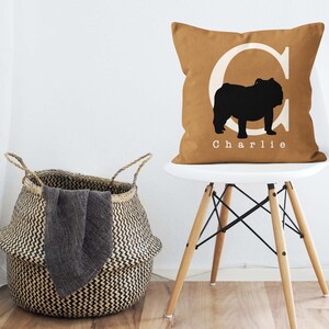 May include: A brown throw pillow with a white letter C and a black silhouette of a bulldog. The pillow has the name "Charlie" printed in white below the bulldog.