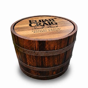 May include: A wooden barrel with the text "ELIJAH CRAIG Small Batch Kentucky Straight Bourbon Whiskey" on the top. The barrel is made of dark brown wood with metal bands around it. The barrel is round and has a rustic appearance.