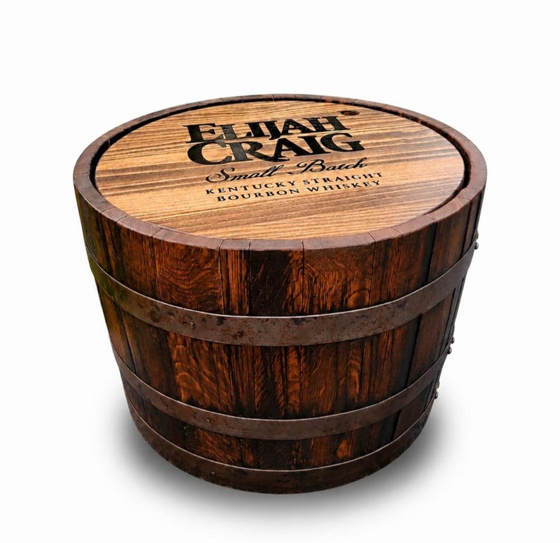 May include: A wooden barrel with the text "ELIJAH CRAIG Small Batch Kentucky Straight Bourbon Whiskey" on the top. The barrel is made of dark brown wood with metal bands around it. The barrel is round and has a rustic appearance.