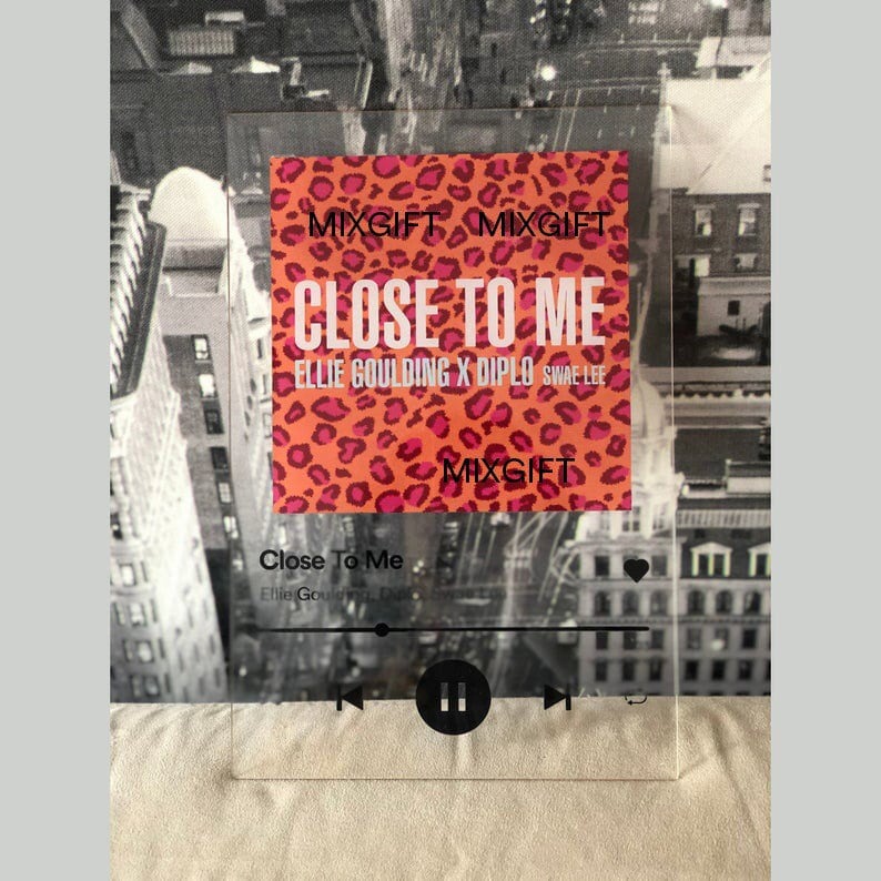 May include: A clear acrylic plaque featuring the song title "Close To Me" by Ellie Goulding, Diplo, and Swae Lee. The design includes a leopard print background and a music player interface. The plaque has the text "MIXGIFT" on it.