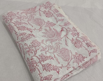 May include: White fabric with a pink floral print. The fabric is folded in half and the print is visible on both sides.