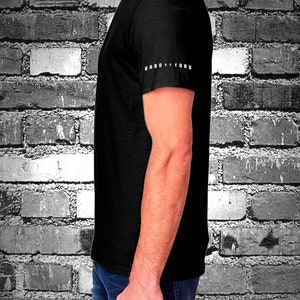 May include: A black t-shirt with the text "RABO DE FORRO" printed on the sleeve.