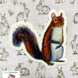 May include: A watercolor illustration of a squirrel with a bushy tail. The squirrel is brown and white with a light blue underbelly. The squirrel is standing on its hind legs with its front paws crossed. The background is a white surface with a pattern of brown rabbits.