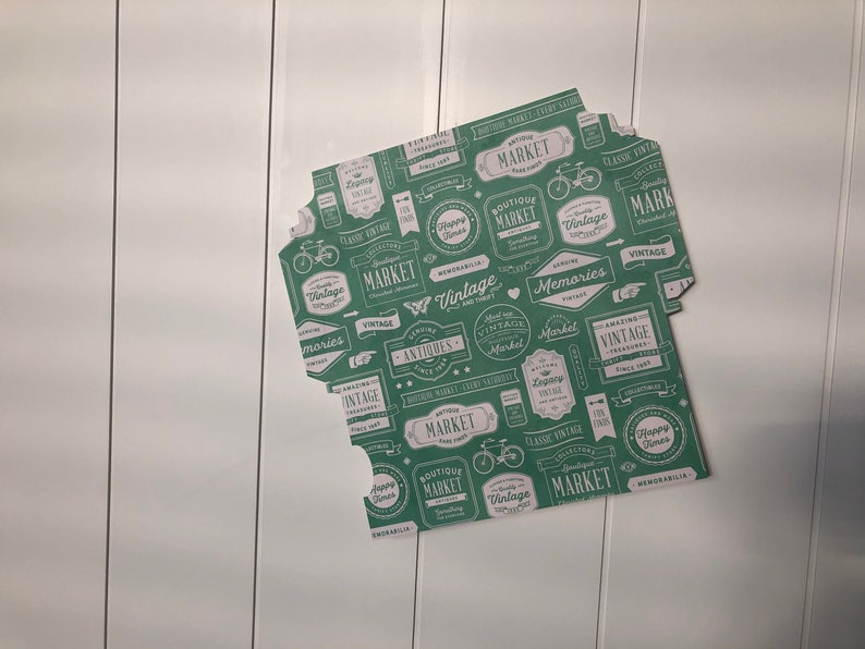 Puede incluir: Papel estampado verde y blanco con un tema de mercado vintage. El papel presenta varias etiquetas y dise&ntilde;os con palabras como "Vintage", "Mercado", "Antig&uuml;edades" y "Recuerdos".