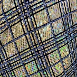 May include: A gold fabric with a black and silver checkered pattern. The fabric is iridescent and has a glittery finish.