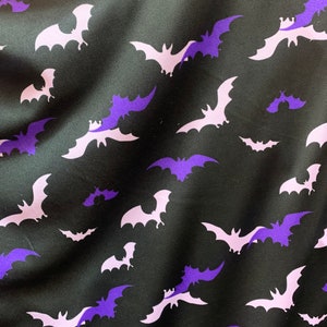Paarse en witte vleermuizen op zwarte spandexstof