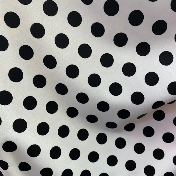 White base with black polka dot fabric sold by the yard