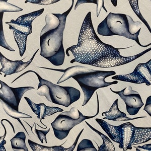 Peut inclure: Un tissu blanc avec un motif répété de raies manta bleues. Les raies manta sont stylisées et ont un motif de points.