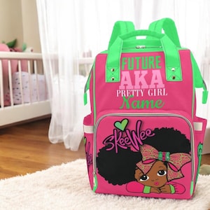 May include: Pink and green backpack with a black and brown illustration of a girl with a bow. The backpack has the text "Future AKA Pretty Girl Name" on the front.