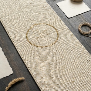 May include: A white ceramic mug with a black handle and the text "But First, Coffee" in a black, handwritten-style font. The mug is on a white surface.