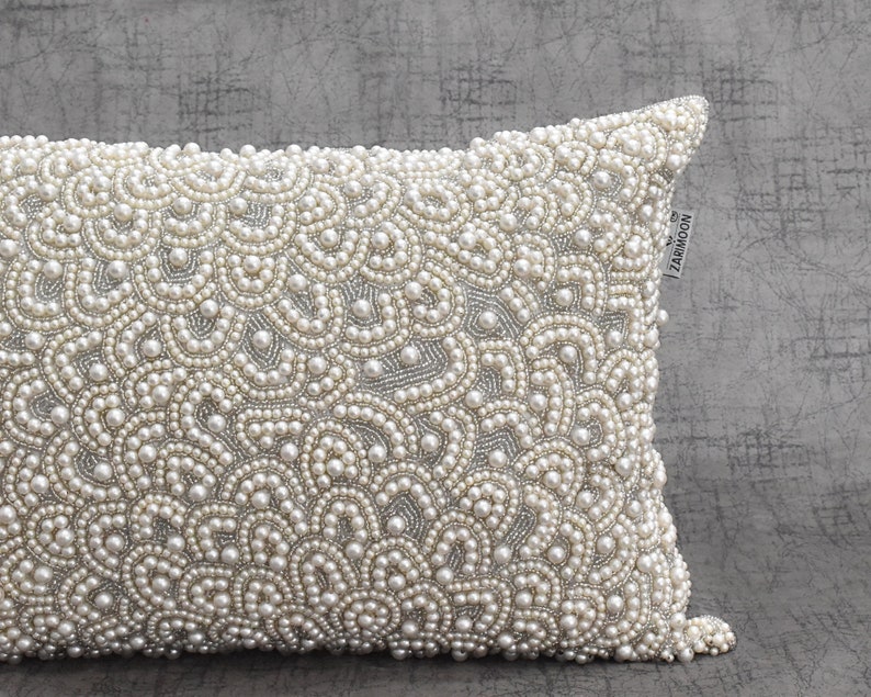 Puede incluir: Una funda de coj&iacute;n blanca con un dise&ntilde;o de perlas. La funda de coj&iacute;n est&aacute; hecha de una tela suave y lujosa y es perfecta para agregar un toque de elegancia a cualquier habitaci&oacute;n. La funda de coj&iacute;n est&aacute; adornada con una peque&ntilde;a etiqueta que dice "ZARMOON".