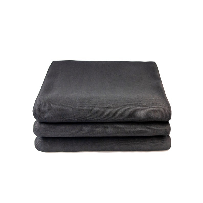 May include: Three black fabric placemats stacked on top of each other.