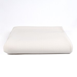 May include: A folded white cotton fabric, possibly a sheet or tablecloth, with a smooth texture.