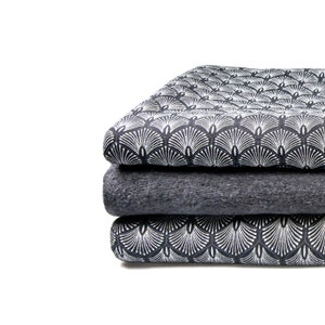 May include: A stack of three fabric swatches. The top and bottom swatches feature a black and white geometric pattern. The middle swatch is a solid dark gray.