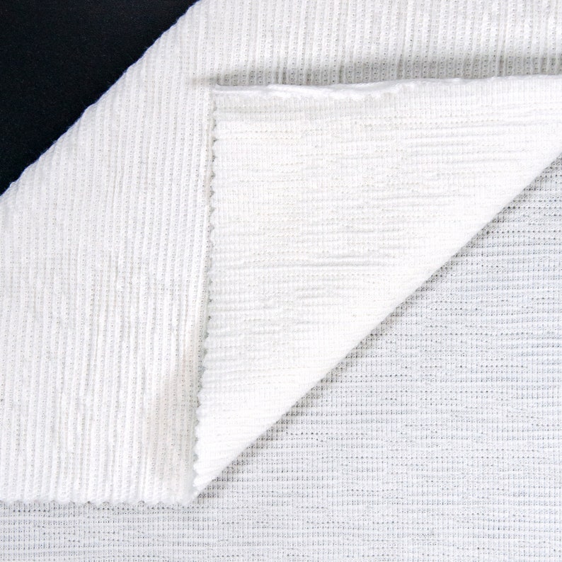 May include: Two pieces of white fabric with different textures. One piece has a ribbed texture, and the other has a fine, woven texture.