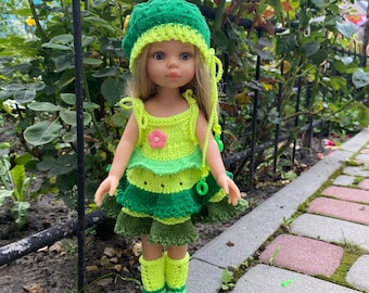 May include: A doll wearing a green and yellow knitted dress, hat, and boots. The doll has blonde hair and blue eyes.