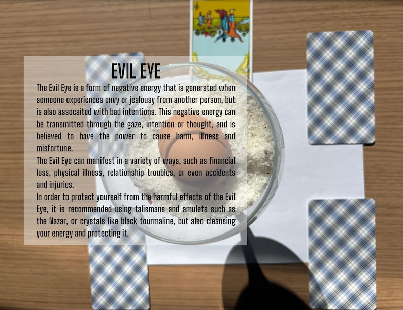 May include: A clear glass bowl filled with white salt and a single brown egg, surrounded by four tarot cards with blue and white plaid backs and one card showing a figure, with text overlay explaining the concept of the Evil Eye in detail.