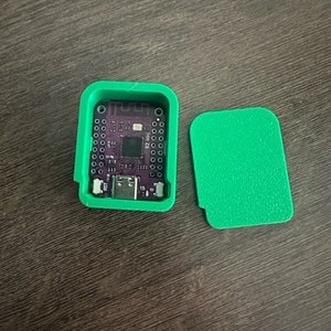 Könnte beinhalten: Ein grünes Plastikgehäuse mit einer lila Leiterplatte im Inneren. Das Gehäuse hat einen USB-Anschluss und ist geöffnet, wodurch die Leiterplatte sichtbar wird.