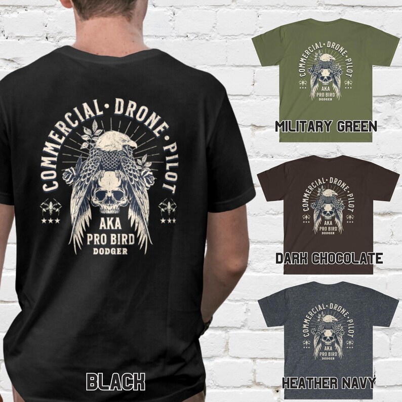 May include: Black, military green, dark chocolate, and heather navy t-shirts with a graphic print of a skull with wings and the text "Commercial Drone Pilot AKA Pro Bird Dodger".