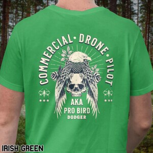 May include: A green t-shirt with a graphic of a skull with wings and the text "Commercial Drone Pilot AKA Pro Bird Dodger".