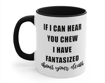 May include: White ceramic coffee mug with a black rim and handle. The mug has black text that reads "If I can hear you chew I have fantasized about your death."