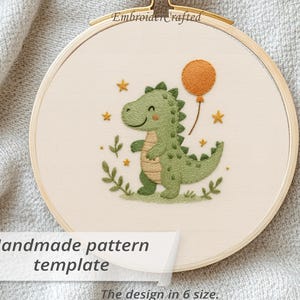 Pode incluir: Arte de bordado em bastidor com um simpático dinossauro verde segurando um balão laranja. O design inclui estrelas e folhagens, com o texto "Handmade pattern template" e "The design in 6 size." O bastidor é de madeira.