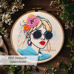 May include: Embroidered hoop art featuring a woman with sunglasses and a flower in her hair. The artwork uses blue, pink, orange, and yellow thread on a cream-colored fabric. The text "PDF Instant Download" is visible.