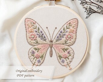 May include: A hand-stitched butterfly embroidery in a wooden hoop. The butterfly features pink, lavender, and peach floral details. The text "Original embroidery PDF pattern" is visible.