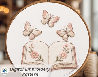 May include: A digital embroidery pattern featuring a book and butterflies. The design includes three butterflies above an open book with floral accents. The embroidery is in shades of pink, beige, and brown, set within a wooden embroidery hoop.