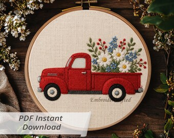 May include: A circular embroidery hoop containing a fabric panel with a stitched design of a red vintage pickup truck carrying a bouquet of white daisies, blue flowers, and red berries. The text "Embroidrafted" is stitched in small letters.