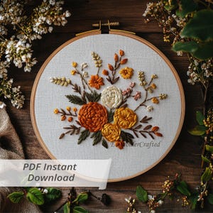 Könnte beinhalten: Ein floraler Stickrahmen mit einem Bouquet aus orangefarbenen, gelben und cremefarbenen Blumen mit grünen Blättern. Der Text "PDF Instant Download" ist auf dem Bild zu sehen.