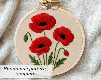 May include: An embroidered hoop art piece featuring three vibrant red poppy flowers with black centers and green stems and leaves. The text "Handmade pattern template" is visible. The design is set in a wooden hoop.