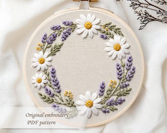 May include: Embroidered floral hoop art featuring a wreath of white daisies, purple lavender, and yellow accents. The embroidery is set on a beige fabric, framed by a wooden hoop. Text on the image reads "Original embroidery PDF pattern."