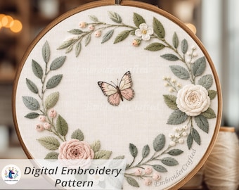 May include: A handcrafted embroidery hoop featuring a butterfly and floral design. The artwork includes a butterfly with pink and brown wings, surrounded by embroidered leaves, roses, and small flowers. The text "Digital Embroidery Pattern" is visible at the bottom.