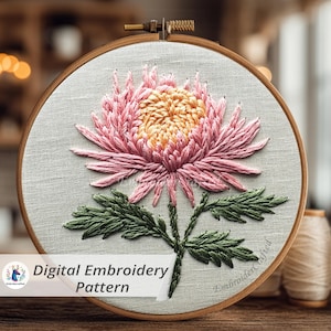 Op de afbeelding: Digitaal borduurpatroon van een roze en gele chrysant, geborduurd op lichtgrijze stof. Het ontwerp is ingelijst in een houten borduurring. De tekst "Digital Embroidery Pattern" staat linksonder.