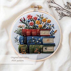 May include: Embroidered hoop art featuring a stack of three books with colorful floral arrangements. The books are in shades of red, blue, and green, with detailed stitching. The text "Original embroidery PDF pattern" is at the bottom.