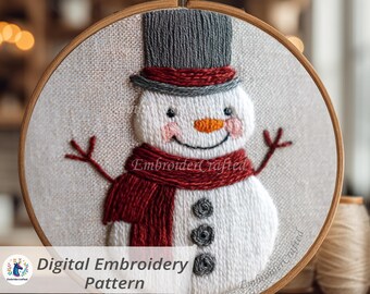 May include: Embroidered snowman design in a wooden hoop. The snowman has a grey top hat, a red scarf, and a carrot nose. The text "Digital Embroidery Pattern" is at the bottom. The design is on a light beige fabric.