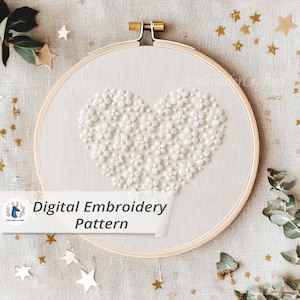 Peut inclure: Un cercle à broder blanc avec un motif floral en forme de cœur. Le cœur est composé de petites fleurs blanches en relief. Le texte "Digital Embroidery Pattern" est affiché sur une bannière blanche en bas de l'image.