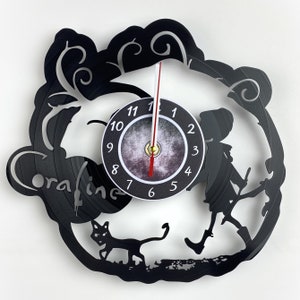 May include: Black vinyl record clock featuring a silhouette of a girl and a cat, with the words "Coraline" and a clock face with Roman numerals.