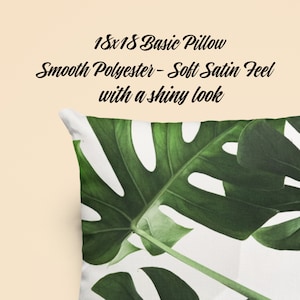 May include: A white pillow with a green tropical leaf print. The pillow is 18x18 inches and made of smooth polyester with a soft satin feel.