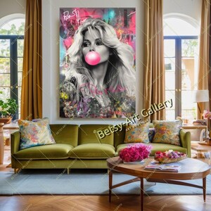 May include: A large pop art style canvas print featuring a black and white image of a woman blowing a bubblegum bubble. The background has colorful graffiti-style accents. The print is displayed above a green sofa.