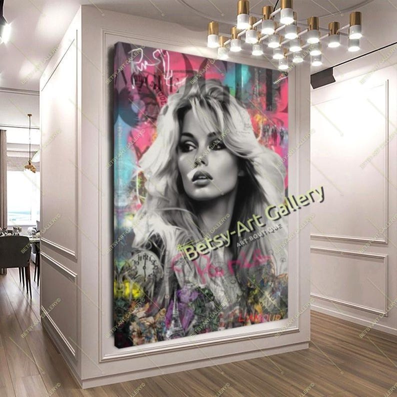 May include: A large framed canvas art print featuring a black and white portrait of a woman with long, wavy blonde hair. The background has colorful graffiti-style elements with the text "Betsy-Art Gallery". The artwork is displayed in a white-walled hallway.