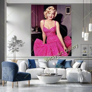 May include: A large wall art print featuring a portrait of Marilyn Monroe in a pink polka dot dress. The image is a vibrant depiction of the iconic actress, perfect for adding a touch of classic Hollywood glamour to any space.