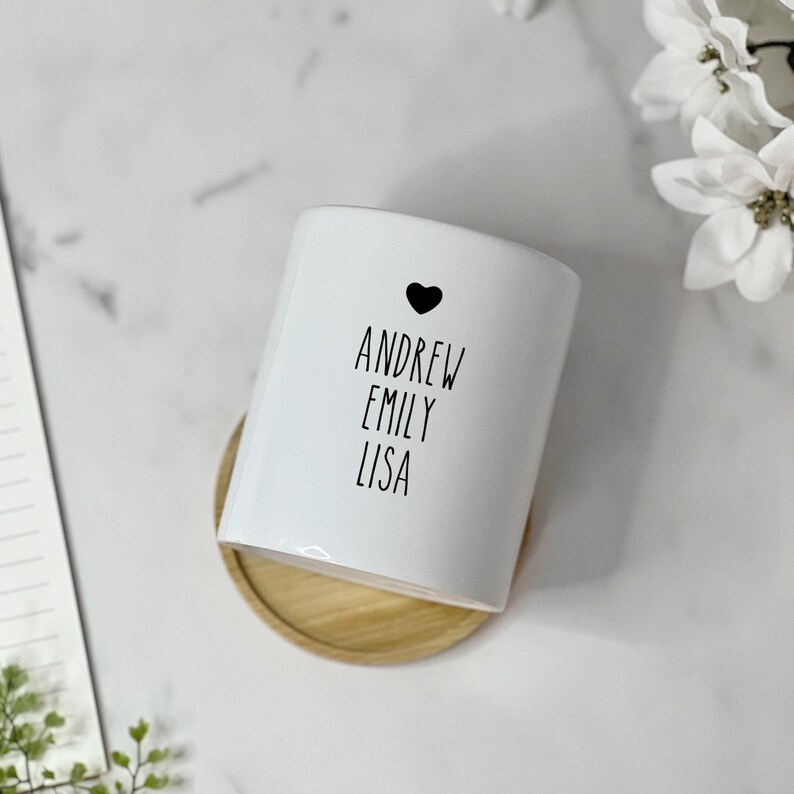 May include: White ceramic planter with a black heart and the names Andrew, Emily, and Lisa written in black.