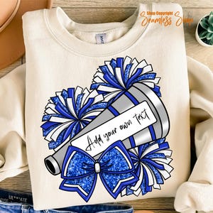 K&ouml;nnte beinhalten: Cremefarbenes Sweatshirt mit einem Cheerleading-Design. Die Grafik zeigt ein silbernes Megaphon, blau-wei&szlig;e Pompons und eine blaue Schleife. Der Text "Add your own text" wird auf einem wei&szlig;en Rechteck angezeigt.