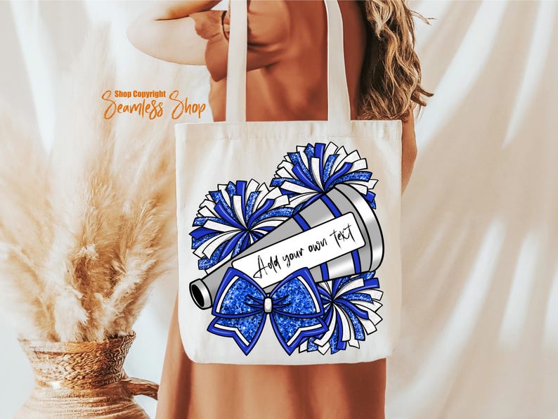 K&ouml;nnte beinhalten: Cremefarbene Tragetasche mit einem Cheerleader-Design. Das Design zeigt ein Megaphon, Pompons und eine Schleife in Blau und Wei&szlig;. Der Text "Add your own text" ist enthalten.