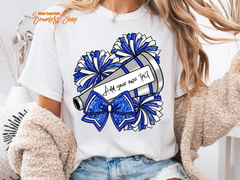 K&ouml;nnte beinhalten: Wei&szlig;es T-Shirt mit einer Grafik eines Megaphons, Pompons und einer Schleife in Blau und Silber. Das Megaphon hat ein Etikett mit der Aufschrift "Add your own text". Das Shirt ist ein l&auml;ssiger Stil.