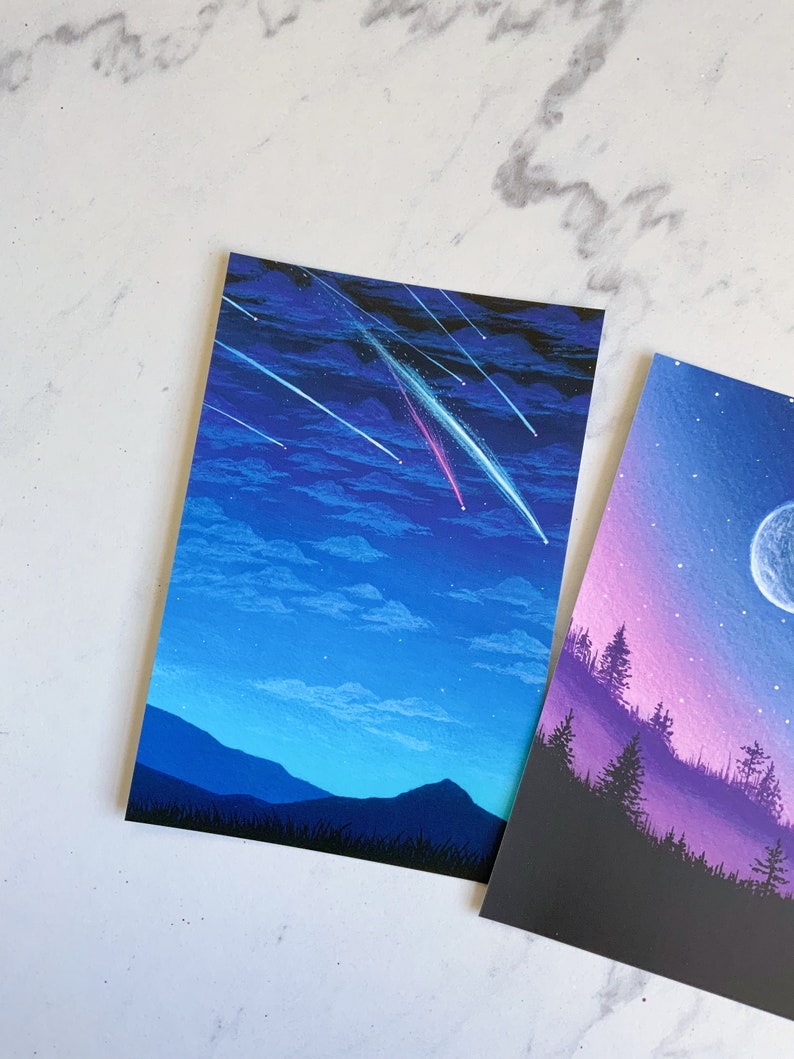 Puede incluir: Una pintura de un cielo nocturno con estrellas fugaces y una cordillera en la distancia. El cielo es de un azul profundo con nubes blancas y las monta&ntilde;as est&aacute;n silueteados contra el cielo.